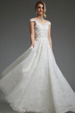 Model wearing Jovani JB05402 off-the-shoulder white dress with lace in front view.