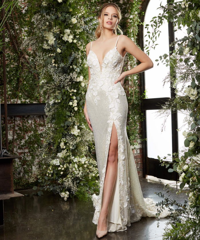 Model wearing JB03592 beige gown with floral appliqués and a high slit, front view.