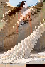 Back view of long lace bridal gown with low V back and dramatic train