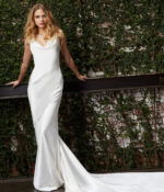 Model wearing Jovani JB03910 white dress with elegant train, front view.
