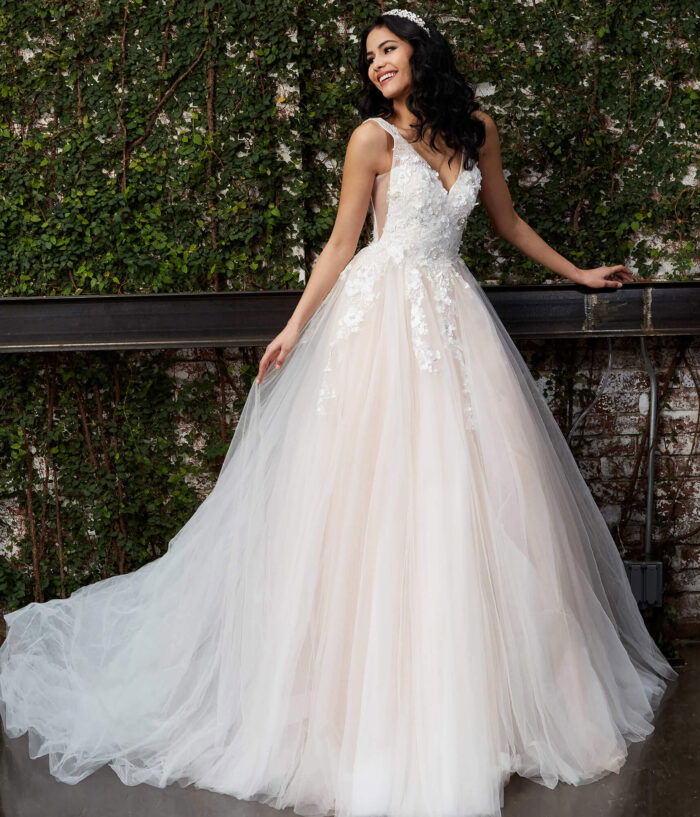 Model wearing Jovani JB05353 white gown with V-neckline and lace appliques