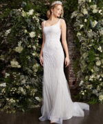 Model posing in Jovani JB06666 white dress with intricate beadwork, front view