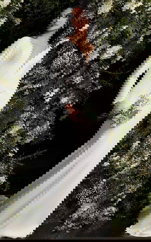 Model wearing Jovani JB06911 ivory gown featuring plunging neckline and long sleeves.