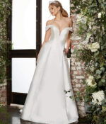 Model wearing Jovani JB07134 elegant ivory A-line gown with off-the-shoulder neckline and beaded detailing, front view.