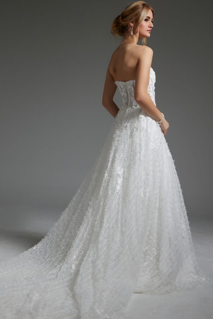 Model wearing Jovani JB07165 white gown with sheer back and floral details, back view.