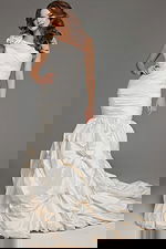 Model wearing Jovani 07179 white gown with one-shoulder neckline and mermaid silhouette, front view.