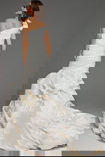 Model wearing Jovani 07179 white gown with one-shoulder neckline and mermaid silhouette, back view.