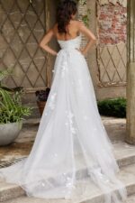 Back view of Jovani JB07452 white gown with elegant trailing overlay.
