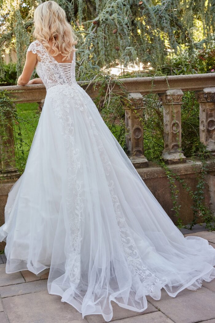 Model wearing Jovani JB07633 dress with lace-up back design and A-line silhouette in ivory, back view.