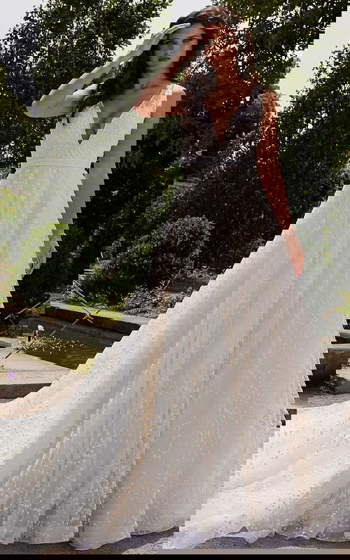 Model wearing Jovani JB09491 white gown with deep v-neckline and floral appliqués