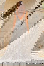 Back view of a lace A-line bridal gown with V-back, floral appliqués, and soft tulle train.