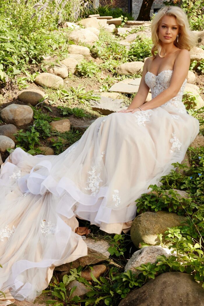 Model seated in JB24145 white lace gown with dramatic train