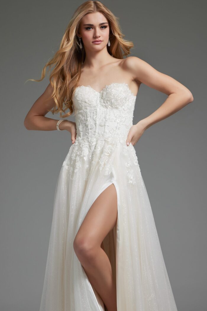 Model in white Jovani JB25730 gown with floral appliqués and high slit, front view.