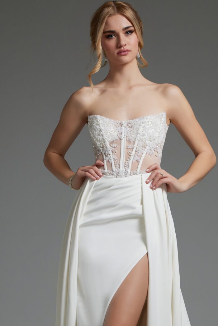 Model showcasing Jovani JB37128 ivory dress's lace bodice and high slit.