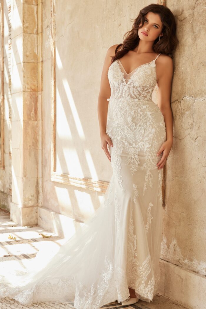 Model in Jovani JB37532 ivory gown with lace and deep V-neckline from the front.