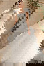 Elegant ball gown wedding dress with tiered tulle skirt and ruffled shoulder straps