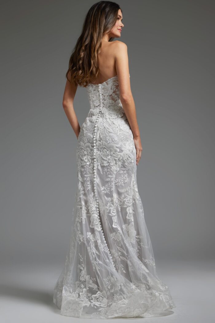Model wearing Jovani JB38221 back view highlighting the covered buttons and detailed lacework of the ivory dress.