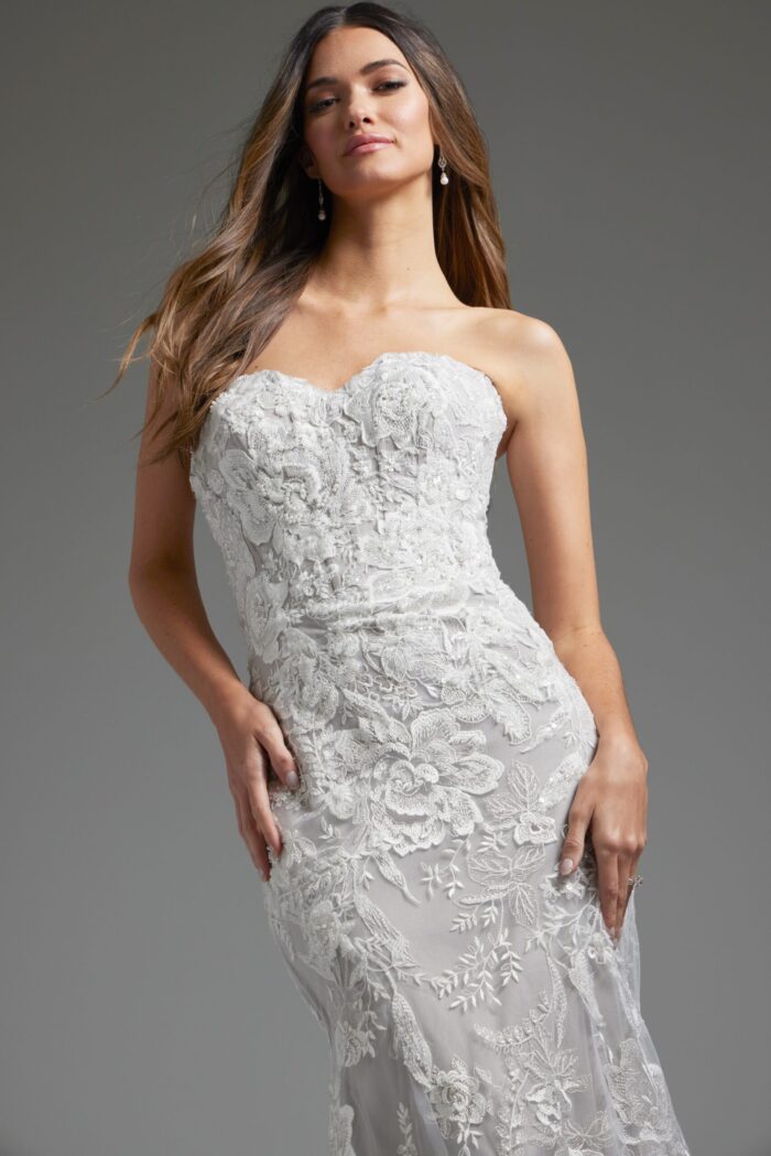 Model wearing Jovani JB38221 showing frontal view of ivory dress with lace details and mermaid silhouette.