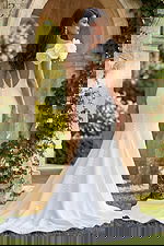 Back view of an off shoulder gown with deep V back, button details, and soft flared train.