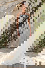 A sleek strapless fit and flare bridal gown featuring clean lines, soft structure, and a button-detailed back for a refined modern look.