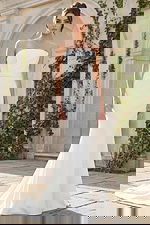 A sleek strapless fit and flare bridal gown featuring clean lines, soft structure, and a button-detailed back for a refined modern look.