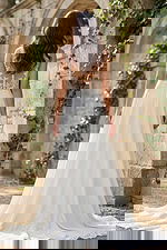 Back view of a flowing A-line bridal gown with lace illusion back, button closure, and soft chapel train