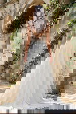 Back view of a flowing A-line bridal gown with lace illusion back, button closure, and soft chapel train