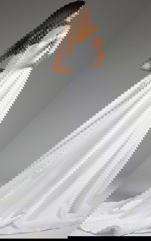 Back view of model in Jovani JB42626 showing the buttoned detail on white dress.