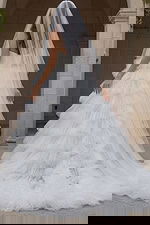 Back view of one shoulder tiered tulle wedding gown.