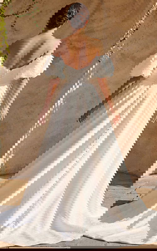 Romantic textured bridal dress with fitted bodice button back and flowing chapel train