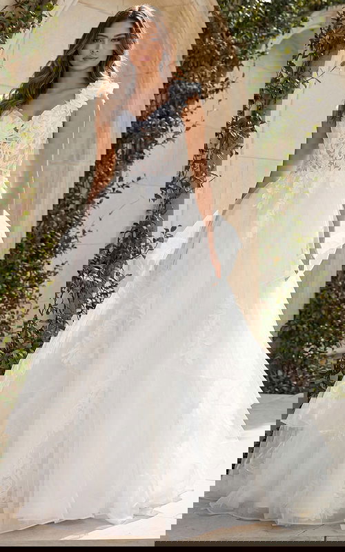 A-line wedding gown with layered tulle skirt, floral appliqué bodice, and 3D flower shoulder detail.