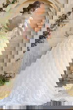 sheer lace sleeve wedding dress with low back and flowing embroidered skirt