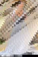 sheer lace sleeve wedding dress with low back and flowing embroidered skirt