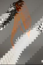 Model showing the back view of Jovani JB43322 ivory gown with open back and cowl drape.