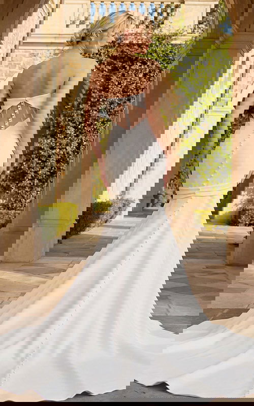 Back view of mermaid bridal gown featuring sheer panel details and a row of covered buttons.