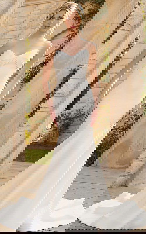 Elegant strapless mermaid wedding dress with soft sweetheart bodice and flowing train.