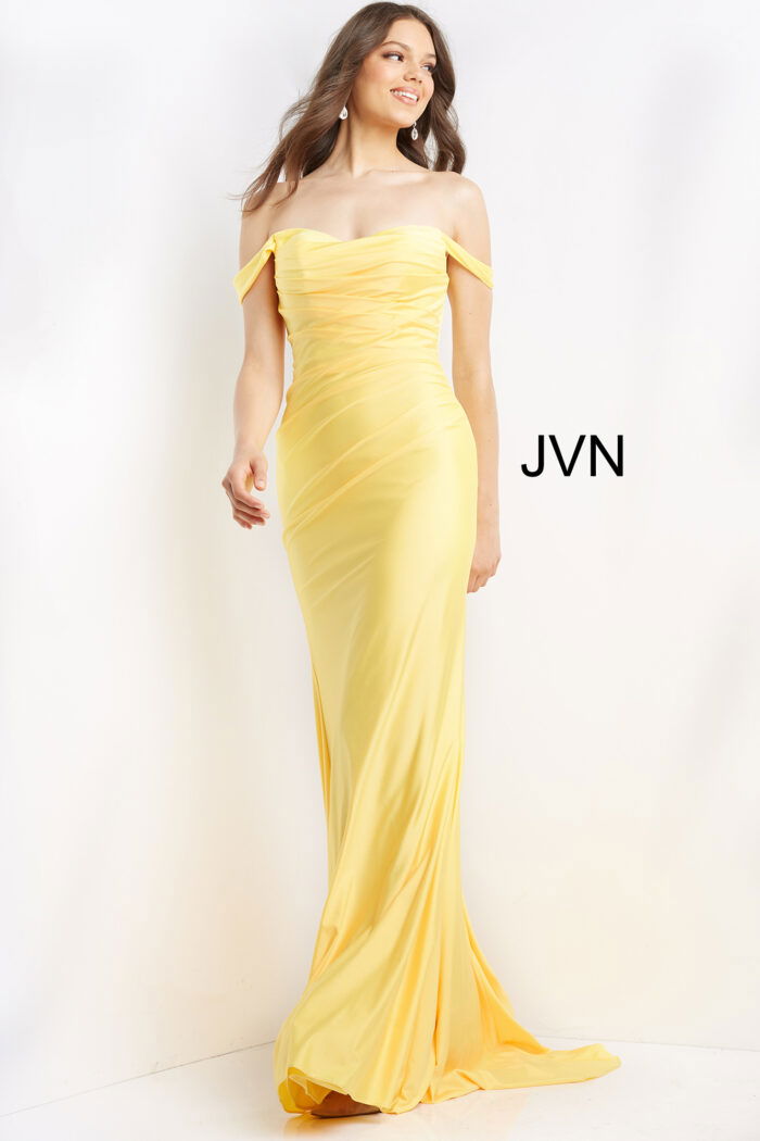 Model in Jovani 07639 yellow gown, displaying off-shoulder design and floor-length silhouette.