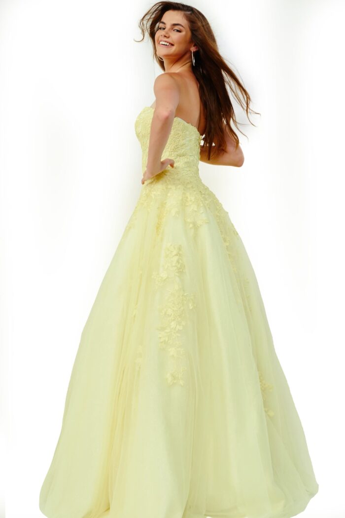 Model wearing Jovani 1831 ball gown in yellow, back view