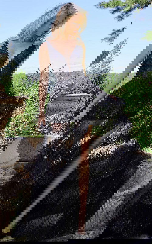 Model wearing JVN22904 black gown with deep V-neck and ruffled skirt front view