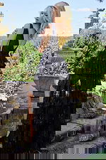 Model wearing JVN22904 black gown showing back view with layered ruffles