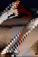 Model wearing Jovani 38487 silver gown with lace detailing and slit.