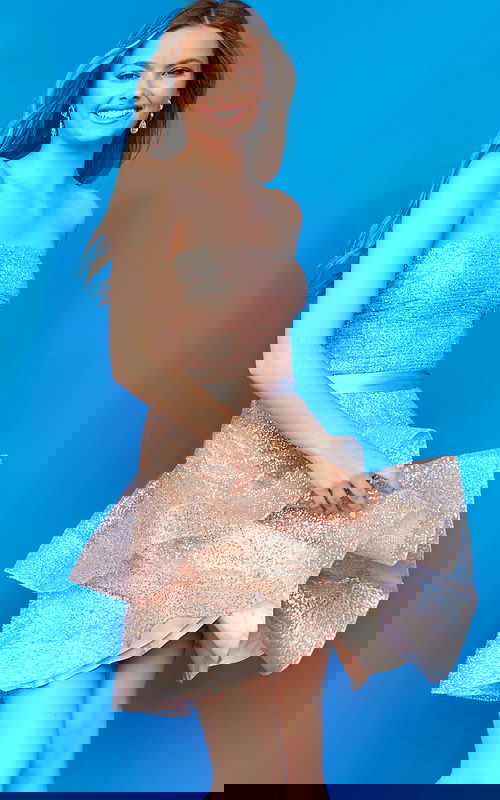 Model wearing K03525 side view with blue background in pink shimmering dress.