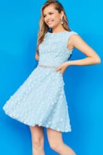 Model wearing K07246 blue dress with detailed floral appliqués and beaded waistband.