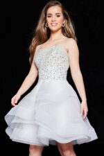 Front view of model wearing ivory Jovani K24050 dress with embellished bodice.