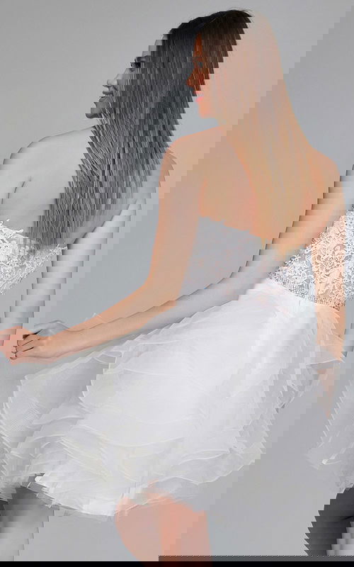 Model wearing Jovani 24371 white dress with intricate lace bodice and tulle skirt, back view.