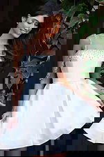 Jovani K48024 pink satin short fit and flare dress back view showing open back with crystal embellished straps, draped rhinestone arm chains, and pleated skirt