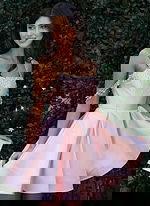 Jovani K48024 pink satin short fit and flare dress close up showing crystal beaded neckline, iridescent draped arm chain details, and full pleated skirt