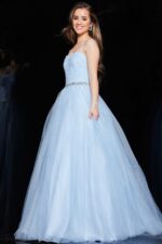 Model wearing Jovani K66712 blue ball gown with flowing tulle skirt.