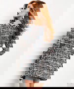 Model wearing Jovani M03273 multi-color tweed mini dress with off-shoulder neckline and fringed details, back view.