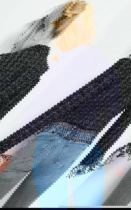 Model turning in Jovani M61912 highlighting back design with fringe trim in multi.